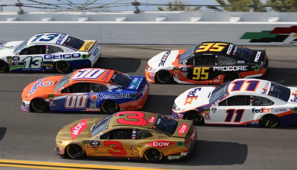 NASCAR cars running close together in a pack