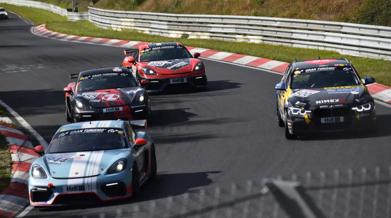 Porsche Cayman GT4 cars overtaking a BMW during an NLS race